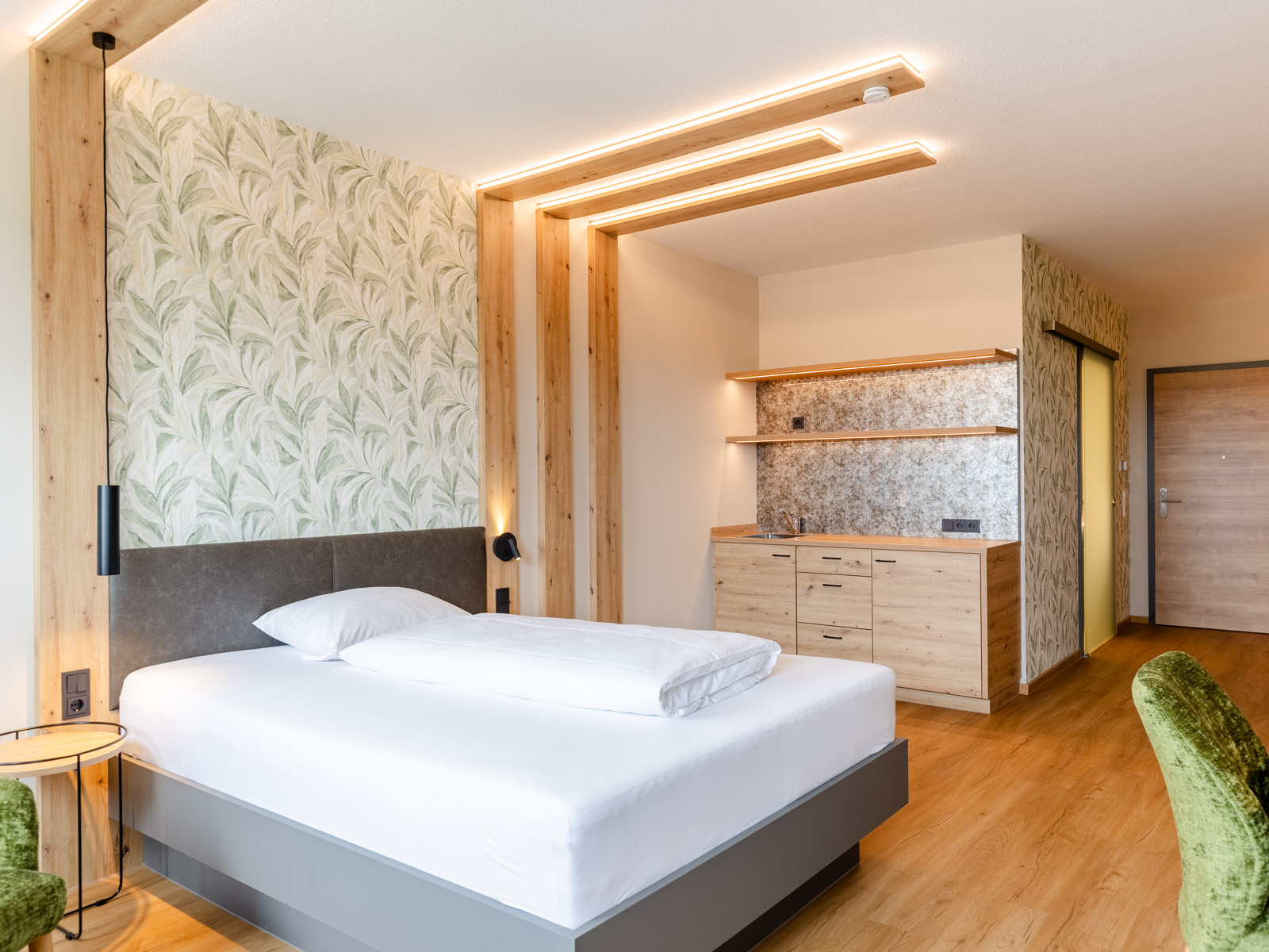 Apartment mit Bett und Küchenzeile im Hintergrund